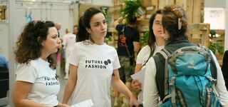 Drei Future Fashion Multiplikatorinnen sprechen angeregt mit einer Messe-Besucherin